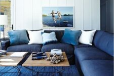 a classic blue rug and a navy sofa plus light blue pillows make the space feel beachy