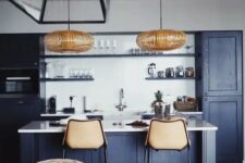 a cool contemporary navy kitchen with white countertops and a backsplash, rattan lamps and leather stools