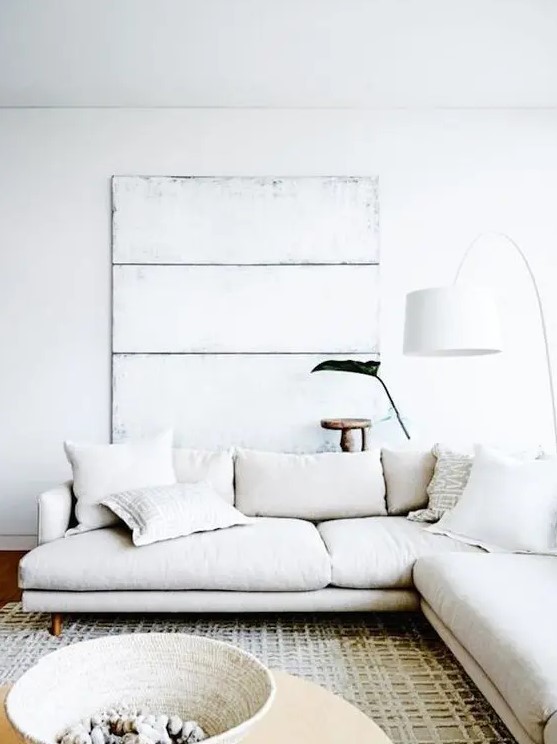 a creamy L shaped sectional sofa for a whitewashed and worn beach inspired contemporary space
