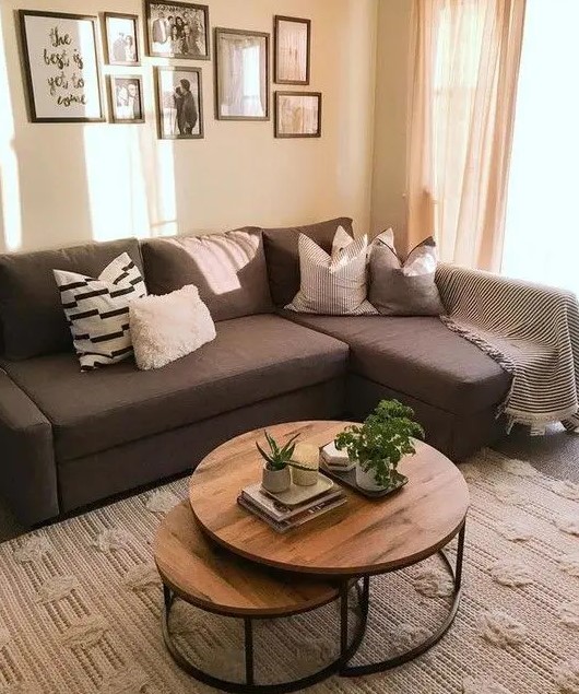 a farmhouse living room with a brown sectional, a duo of coffee tables, a black and white gallery wall is cool