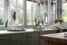 a green cottage kitchen with beadboard cabinets, tall casement windows, white stone countertops and a stained kitchen island