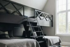 a laconic farmhouse kid’s room with black built-in bunk beds and a ladder, graphite grey bedding and a pouf
