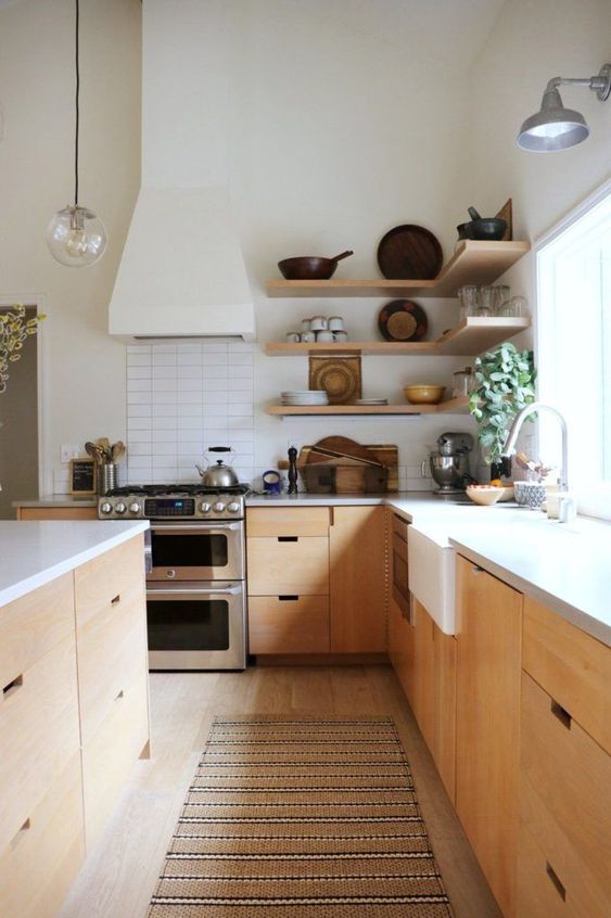a mid century modern kitchen with stained cabinets, a large kitchen island, white countertops, corner open shelves is a lovely space