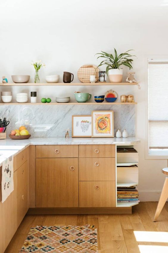 a mid-century modern kitchen with stained cabinets, white stone countertops and a backsplash, open shelves and potted plants