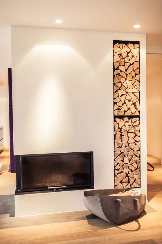 a minimalist white fireplace with a built in niche for storing firewood is a cool idea for a contemporary or minimalist space