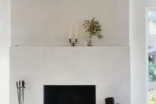 a minimalist white fireplace with decor on the mantel and next to it is a spectacular decor feature for any minimal space