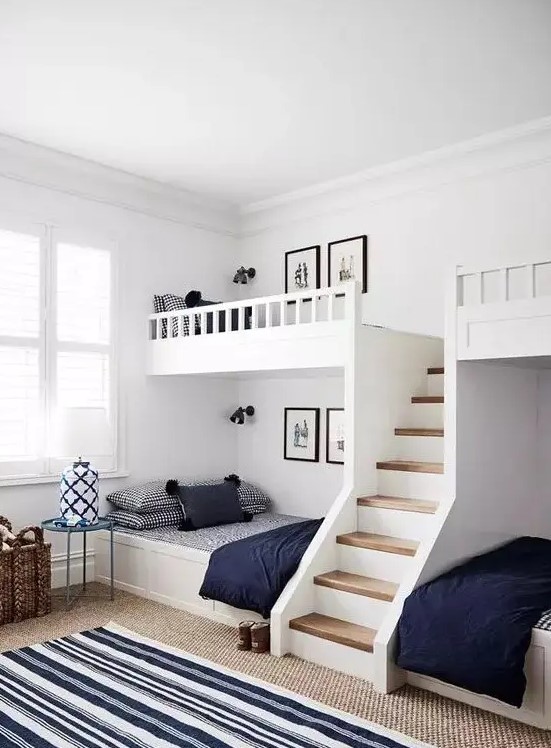 a modern farmhouse kids' room with built-in bunk beds, navy and white bedding, layered rugs and side tables and baskets