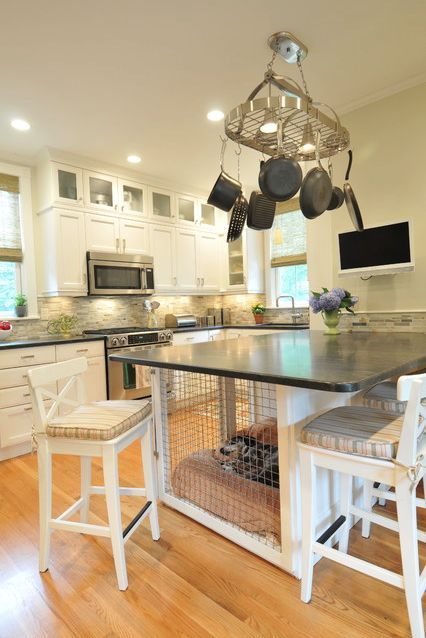 a neutral farmhouse kitchen with flat panel and shaker cabinets, a large kitchen island with a built-in dog crate inside
