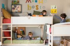 a pretty kids’ room with multiple bunk beds, muted color bedding, a jute rug, some colorful decor