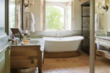 a rustic bathroom with hexagon terracotta tiles, a tub on a wooden stand, a wooden vanity, a wooden table and a large shelving unit