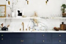a sophisticated navy kitchen with shaker cabinets, a white marble backsplash, countertops and a ledge for displaying various stuff