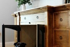a stained TV unit with drawers and a built-in dog crate with black doors is a cool solution to keep your pet safe