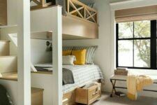 a stylish modern rustic kids’ room with multiple bunk beds with storage drawers, an upholstered bench, a printed rug and bedding