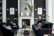 a stylish monochromatic living room with a black accent wall, a fireplace, two consoles, a black sofa and chairs, a tiered glass coffee table