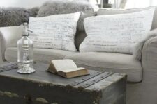 a vintage monochromatic living room with a grey sofa, a black shabby chic chest with black touches and some decor