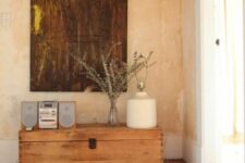 a vintage stained trunk as a console table and a plant stand is a cool addition to a rustic interior