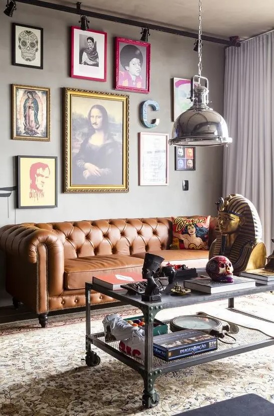 a whimsical industrial living room with a tan leather Chesterfield sofa, a bold and quirky gallery wall and a metal table