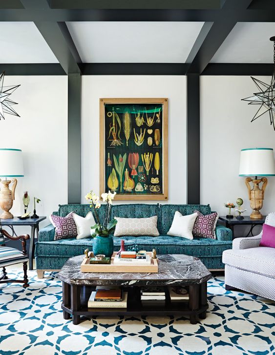 a whimsical living room with a turquoise printed sofa, a stone coffee table, printed chairs and a printed rug