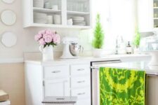 a white farmhouse kitchen with a large kitchen island, open upper cabinets, potted plants, an IKEA stool and bright linens