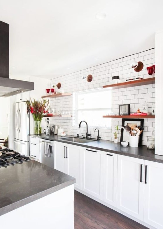 a white farmhouse kitchen with concrete countertops, black handles, rich stained open shelves and appliances is very cool