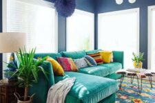 an L-shaped emerald velvet sofa with colorful pillows is the main eye-catcher that adds color to the space