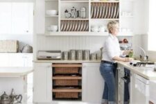 an airy white kitchen with curved cabinets, a kitchen island, an open upper cabinet for displaying dishes and tablware