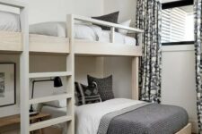 an elegant modern kids’ room in a monochromatic color scheme, with bunk beds, graphic bedding and curtains is a chic idea