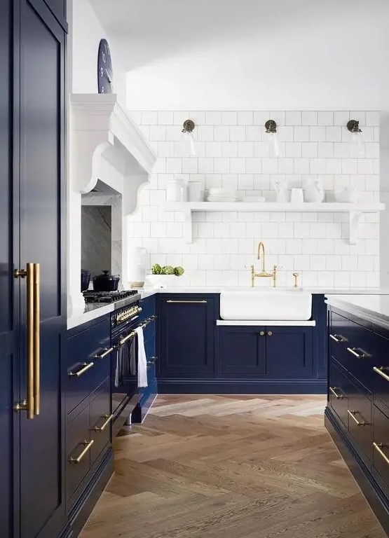an elegant navy kitchen with shaker cabinets, white stone countertops, a large kitchen island, a white square tile backsplash and a white shelf for dishes