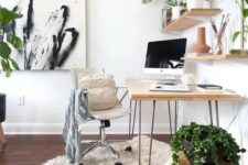a beautiful biophilic home office with a hairpin leg desk, shelves with potted plants and decor, a white chair, an artwork and some plants