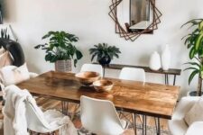 04 a boho dining room with a hairpin leg dining table, white chairs, a hairpin console table, potted greenery, a mirror with a catchy frame