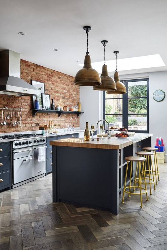 a Victorian meets rustic kitchen with graphite grey cabinets, red bricks and metal pendant lamps