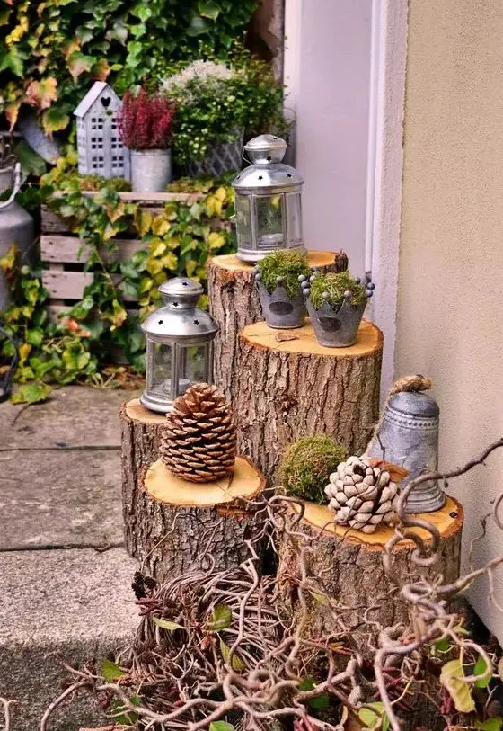 outdoor decor with tree stumps and large pinecones, candle lanterns and buckets with moss and berries is a cool and cozy idea