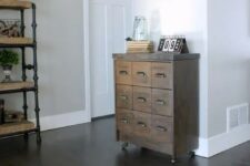 11 a small reclaimed wood apothecary cabinet placed on casters as a cute and eye-catchy entryway console