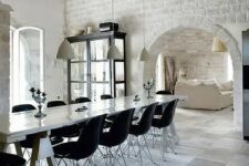 11 white brick going from the walls to the arched ceiling look bold with contemporary furniture in black creating an eclectic look