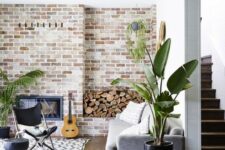12 a boho living room with a whitewashed brick wall, potted greenery and neutral furniture