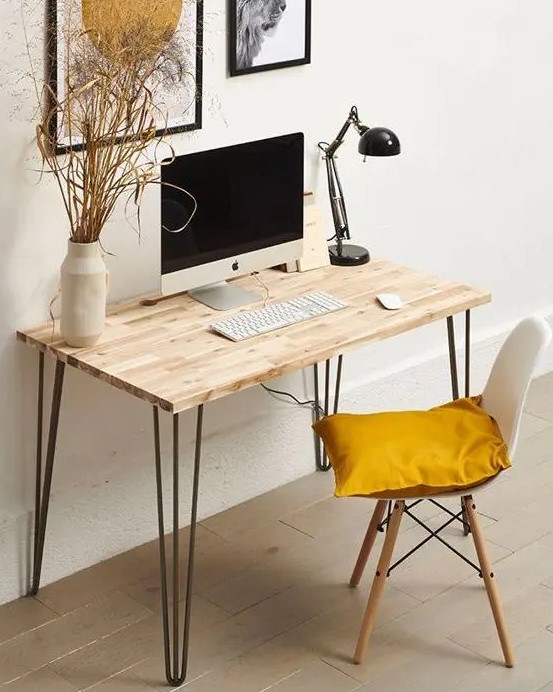 a lightweight hairpin leg desk, a white chair with a pillow, a black table lamp and a mini gallery wall are great for working