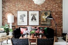 13 a bright boho living room with a red brick statement wall, black furniture and colorful pillows