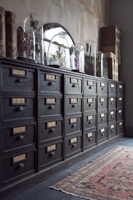 a vintage black card cabinet with an arched mirror, cloches with decor and some books is a beautiful idea for a vintage space