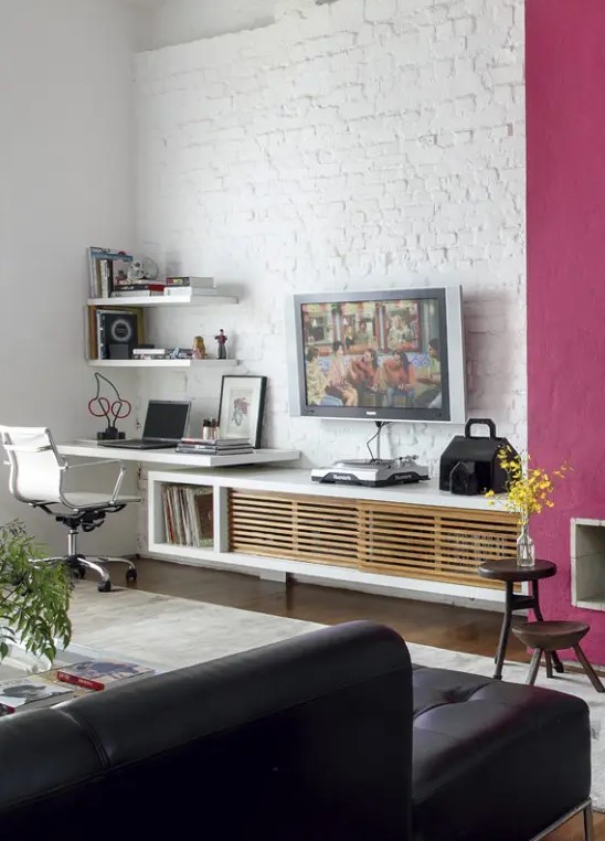 a contemporary living room with a white brick wall and a fuchsia accent plus dramatic dark furniture