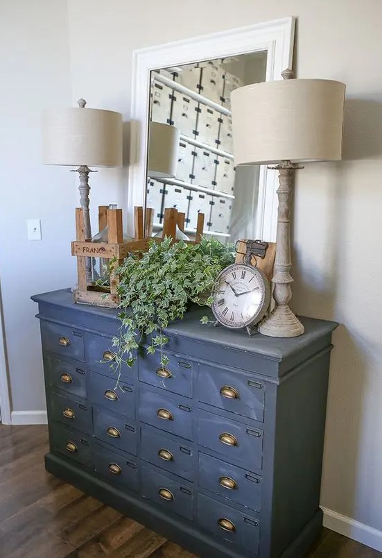 a vintage cabinet painted in graphite grey as a chic and unusual entryway console fo a rustic or vintage space