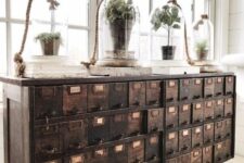15 a vintage dark-stained apothecary cabinet placed on hairpin legs, with cloches with greenery and books is a beautiful idea for a vintage space