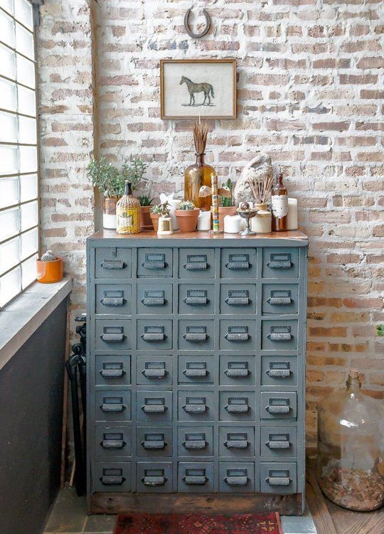 a vintage grey card cabinet with potted plants, dried herbs and candles is a lovely plant stand and storage unit in one