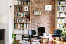 18 a living room with a red brick wall, tall bookcases, a black coffee table, black chairs, potted plants and a pendant lamp