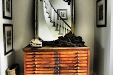 19 a vintage stained file cabinet with a large mirror in a chic frame and some unusual decor will make your entryway wow