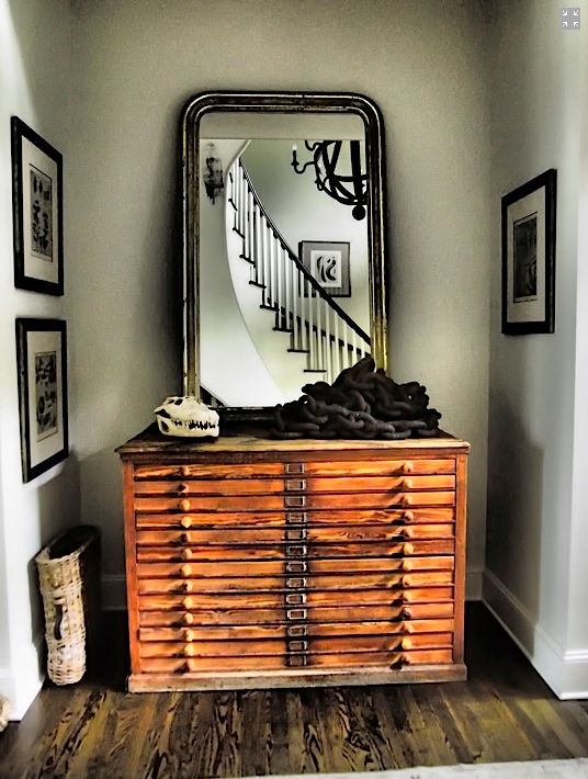a vintage stained file cabinet with a large mirror in a chic frame and some unusual decor will make your entryway wow