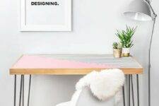 20 a pink and stripe color block desk with hairpin legs, a white chair, a grey floor lamp and an artwork for working