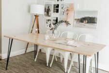 21 a Scandi dining room with a hairpin leg dining table, white metal chairs, a gallery wall and a floor lamp, a printed rug