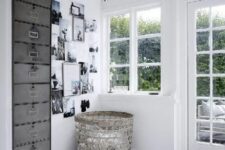 21 a white Scandinavian space with a black and white gallery wall, a basket, a metal file cabinet as a storage unit and a printed rug