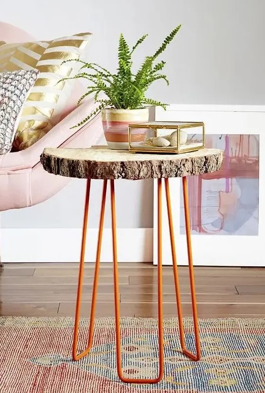 a side table of a tree slice and orange hairpin legs is a cool decor piece for a living room in mid-century modern style