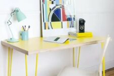 24 a sleek and delicate lightweight desk with neon yellow hairpin legs, a bold artwork, a blue table lamp and white chair